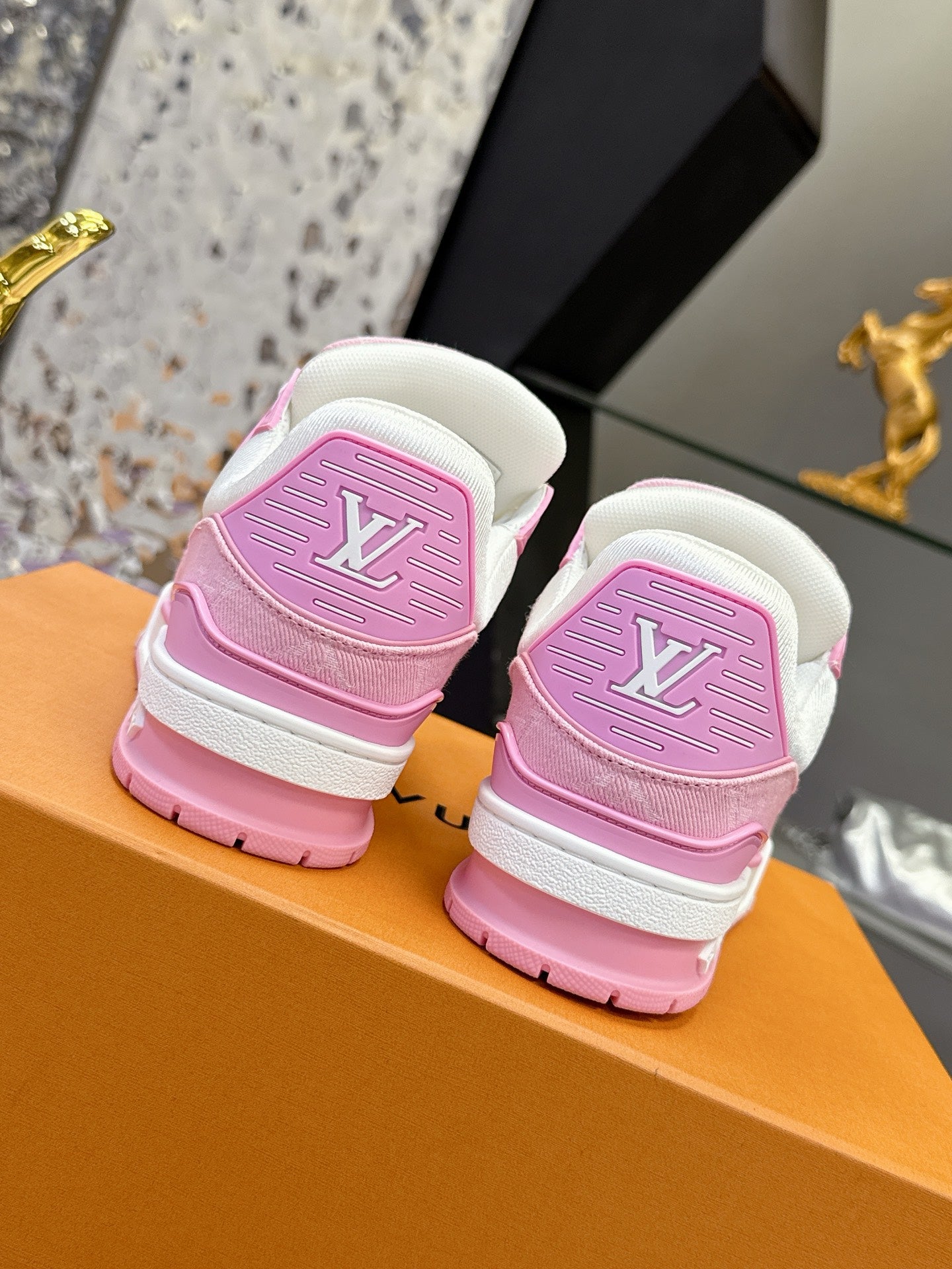 Pink and white Louis Vuitton sneakers back view on orange box, two pairs