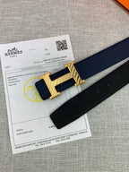 Hermes belt and gold-tone H buckle on packaging paper, shown with dark blue strap