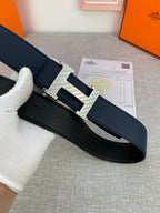 Hermes belt in dark blue with silver-tone buckle, laid flat on packaging paper