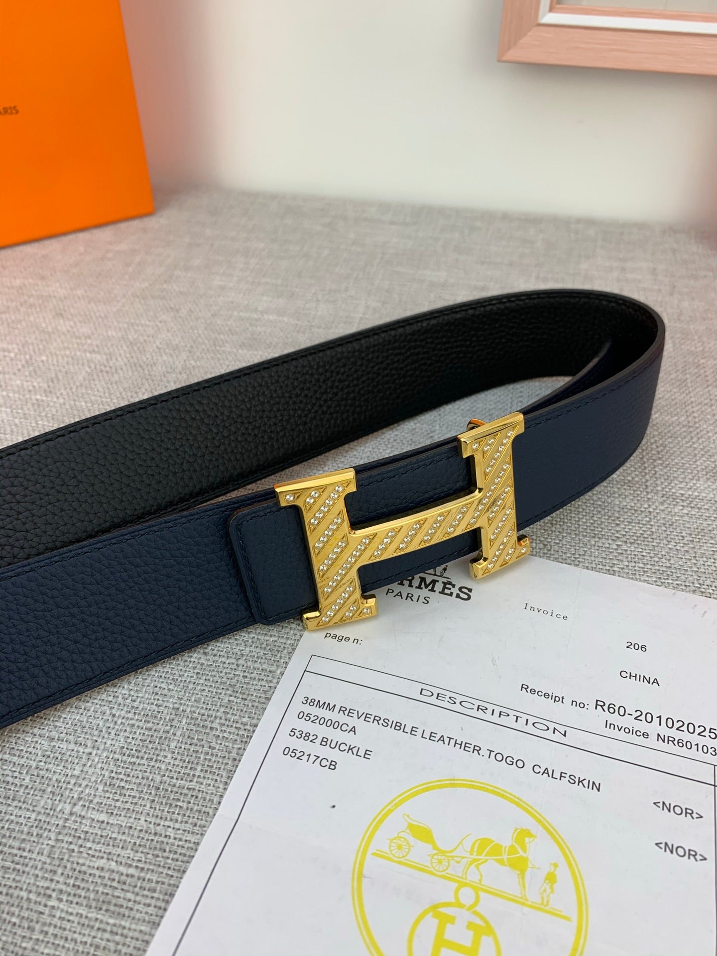 Hermes belt close-up: dark blue leather with gold-tone buckle and keeper