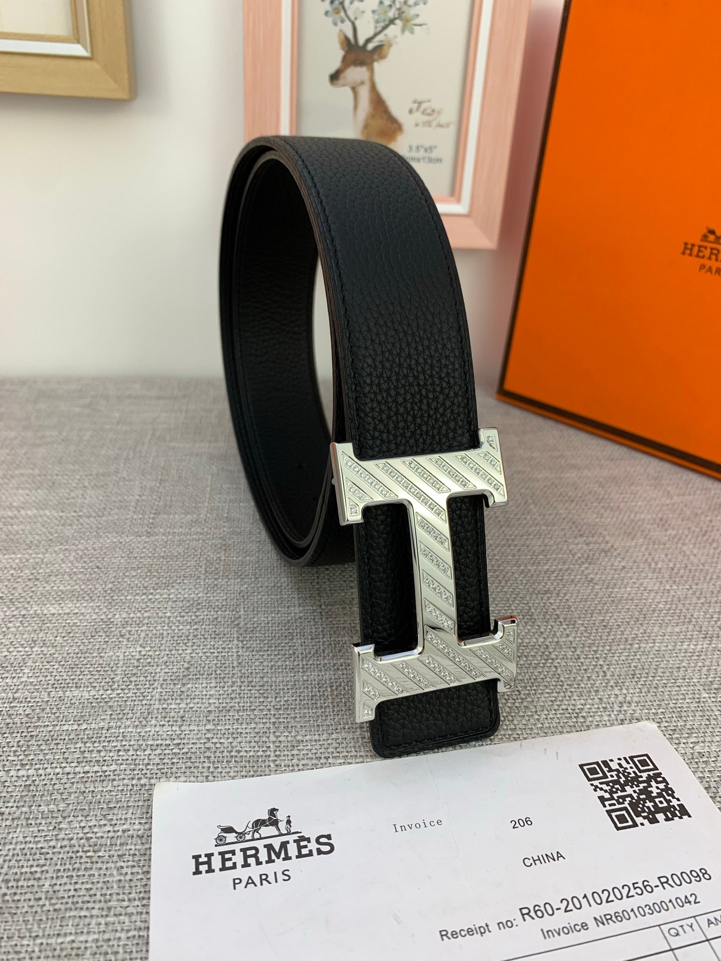 Hermes belt, black textured leather with silver-tone H buckle from side view