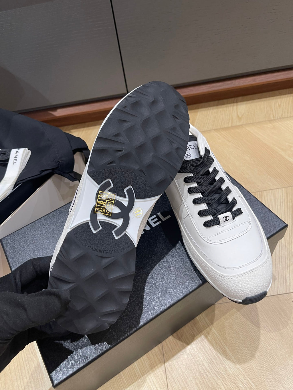 Chanel unisex low-top sneakers, outsole and side view with black tread and laces