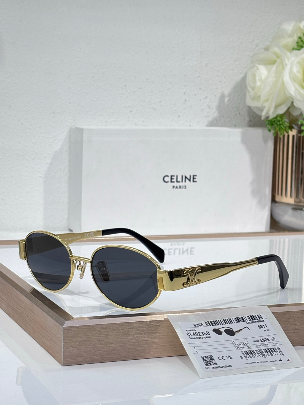 Round sunglasses, gold frame, dark blue lenses, black temple arms