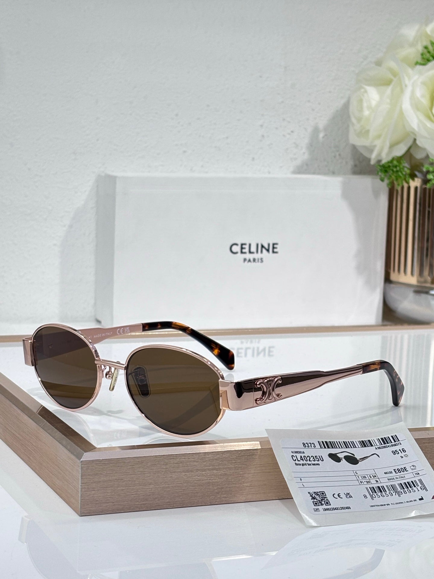 Round sunglasses, light gold frame, brown lenses, black temple arms