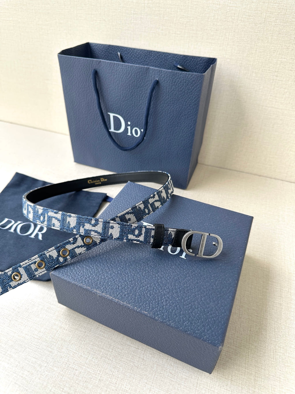 Dior belt laid out, blue monogram webbing with silver CD buckle and black trim.
