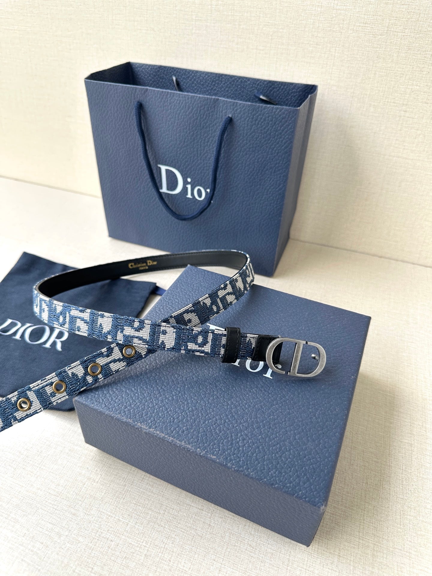 Dior belt laid out, blue monogram webbing with silver CD buckle and black trim.