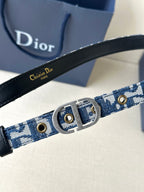 Dior belt close-up with blue monogram webbing, gold studs, and silver buckle.