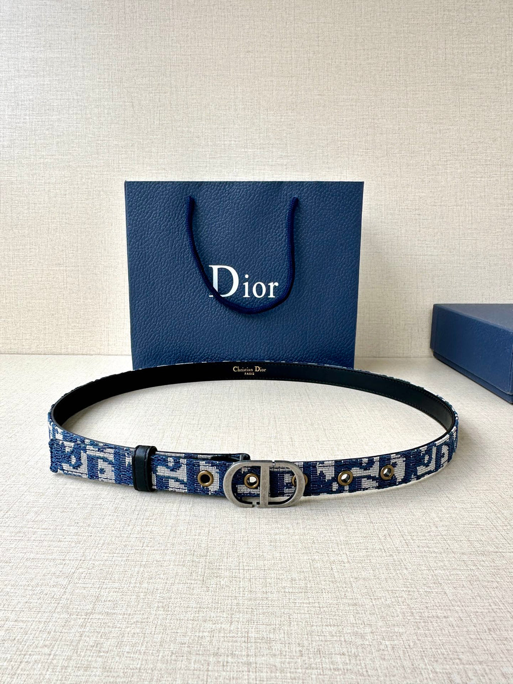 Dior belt with blue monogram strap, black edges, and silver CD buckle.