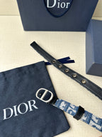 Dior belt detail: blue patterned strap with black leather end and silver buckle