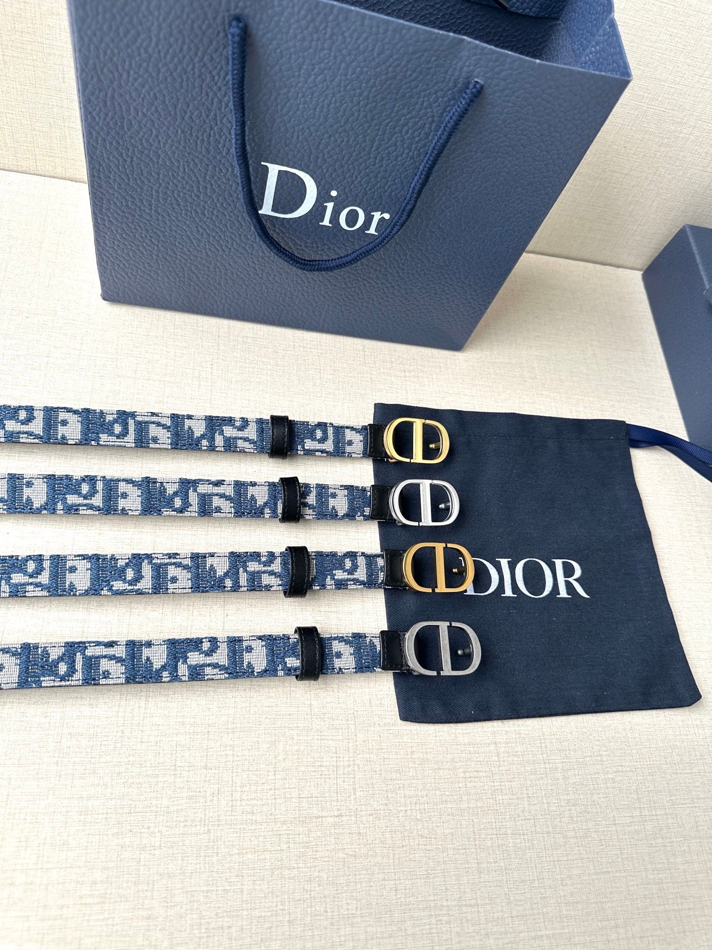 Dior belt set: blue monogram straps with gold CD buckles, three belts shown