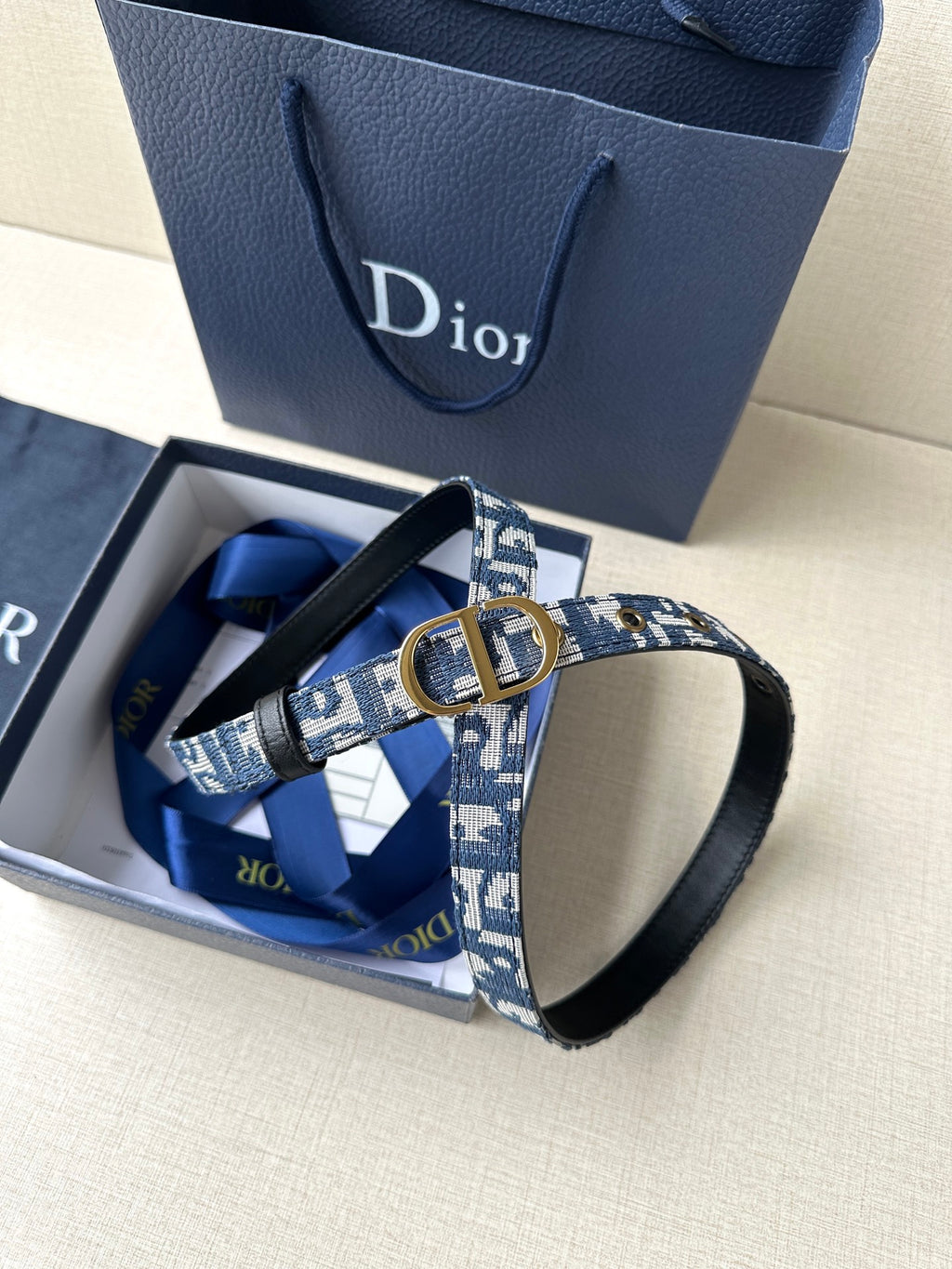 Dior belt in box: blue monogram strap, gold CD buckle and black leather ends