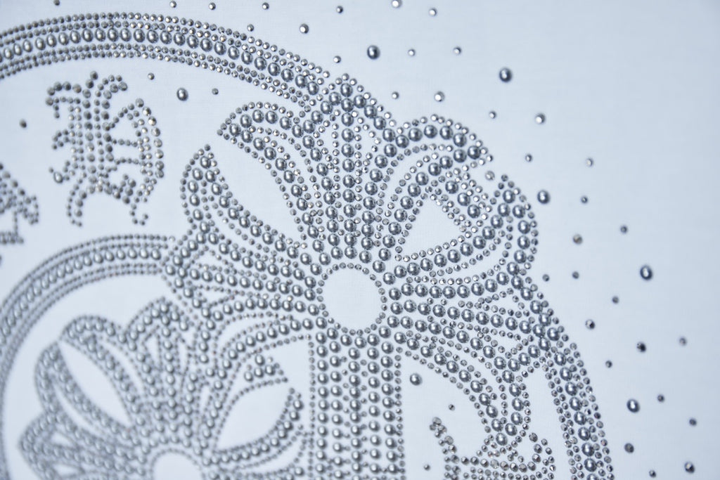 White T-shirt rhinestone medallion close-up with circular dot detailing