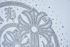White T-shirt rhinestone medallion close-up with circular dot detailing