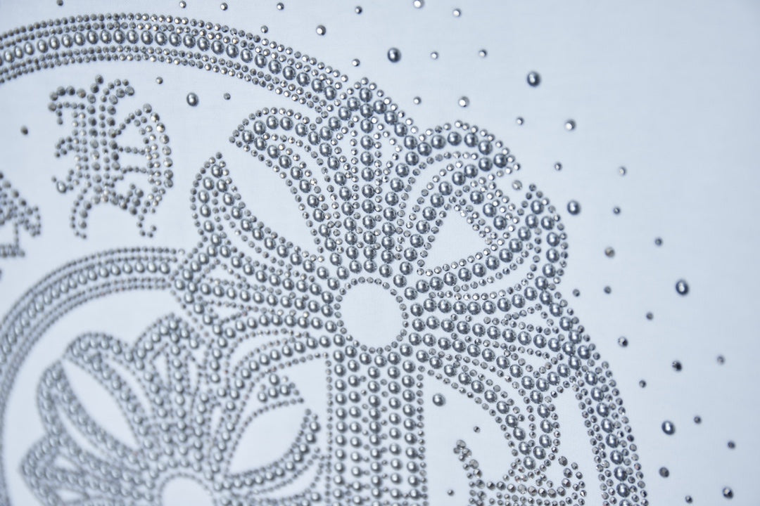 White T-shirt rhinestone medallion close-up with circular dot detailing