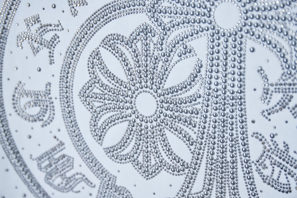 White T-shirt rhinestone medallion close-up with ornate floral pattern