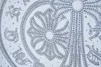White T-shirt rhinestone medallion close-up with ornate floral pattern