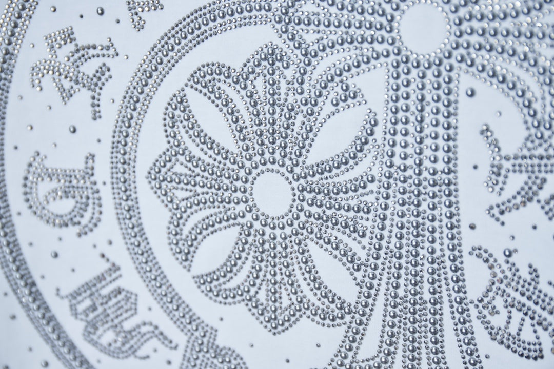White T-shirt rhinestone medallion close-up with ornate floral pattern