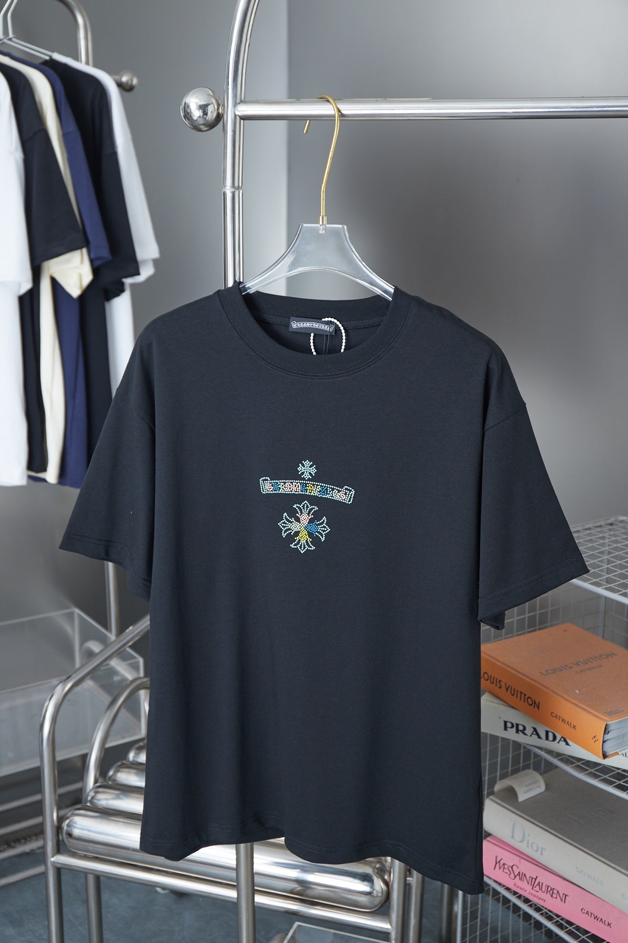 Black crew-neck T-shirt with small rhinestone logo on chest