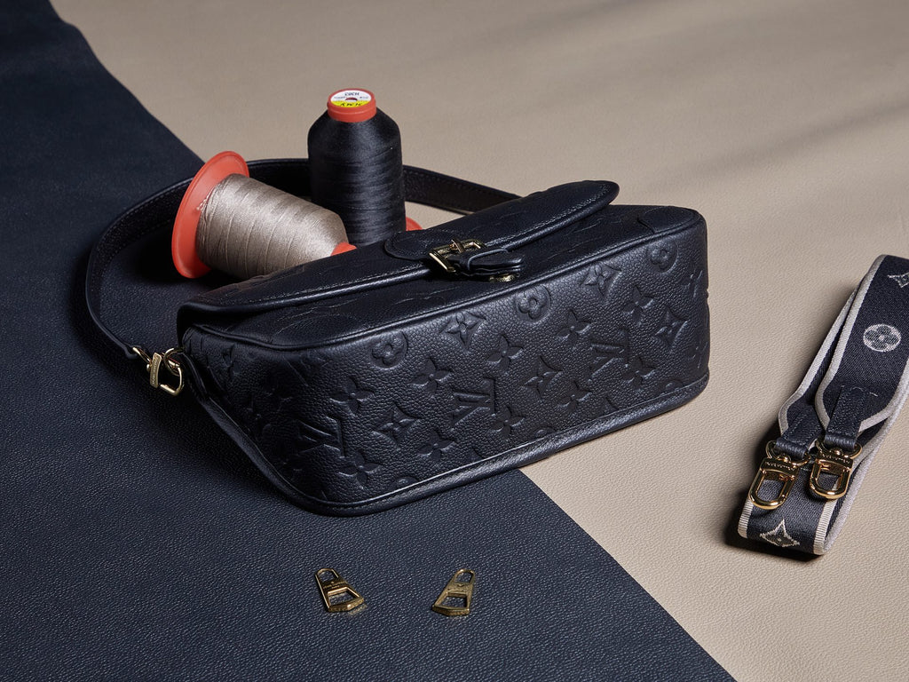Louis Vuitton crossbody bag, dark embossed pattern, zip top with gold hardware