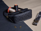 Louis Vuitton crossbody bag, dark embossed pattern, zip top with gold hardware