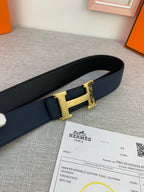 Hermes belt close-up: dark navy strap with gold-tone H buckle and keeper