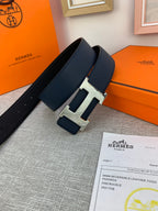 Hermes belt with dark navy strap and silver-tone H buckle on display