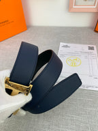 Hermes belt close-up: dark navy strap with gold-tone H buckle and end tab