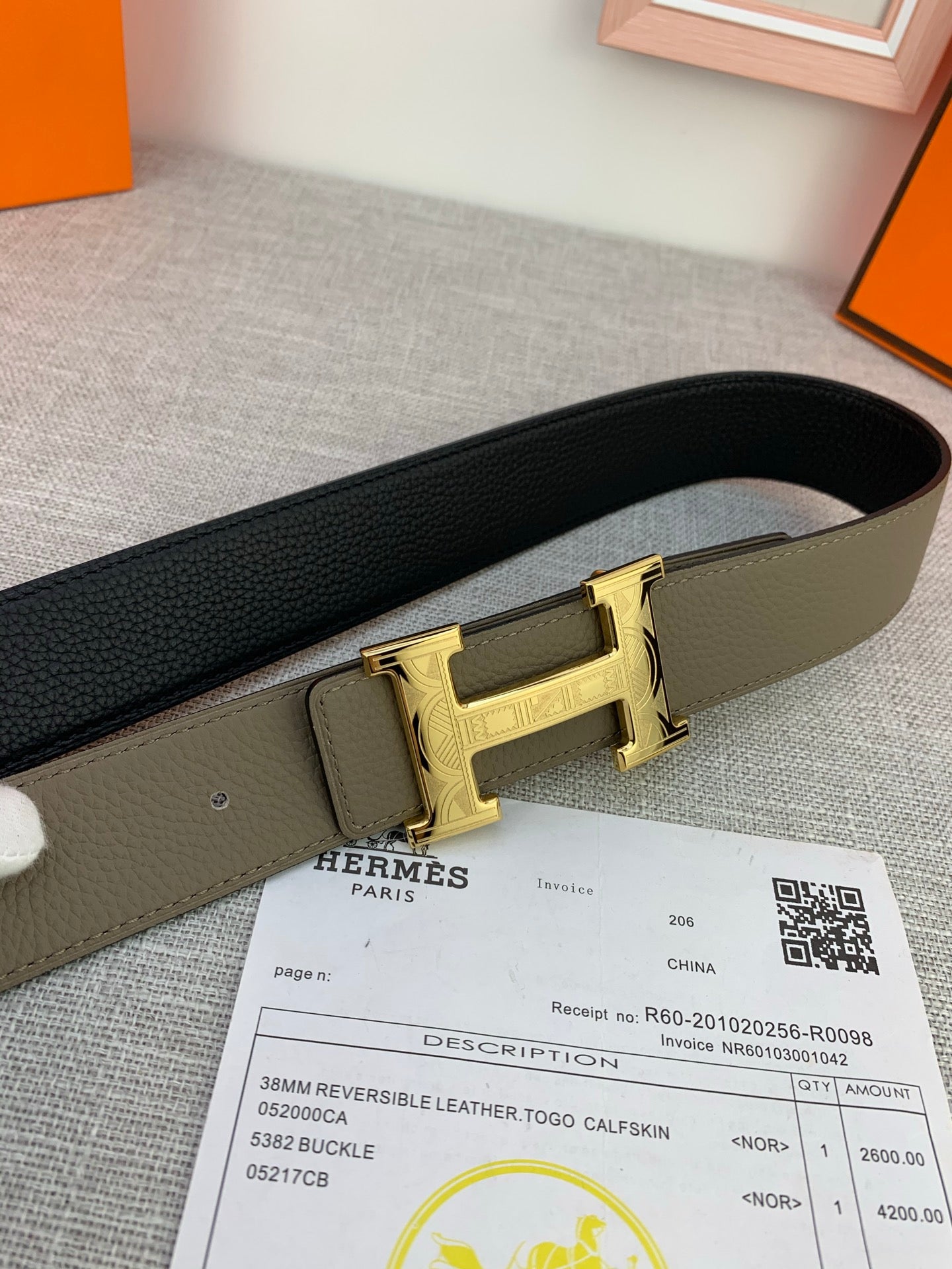 Reversible leather belt with gold-tone buckle, olive exterior and dark interior strap.
