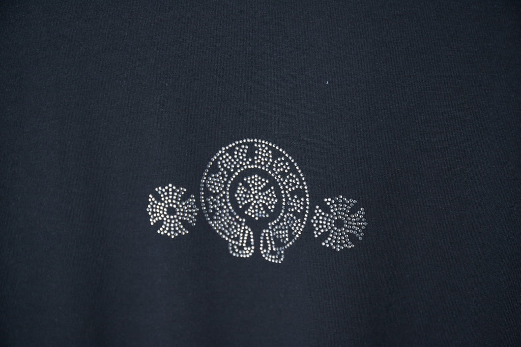 Dark blue T-shirt chest emblem with rhinestone-style circular logo and floral motifs