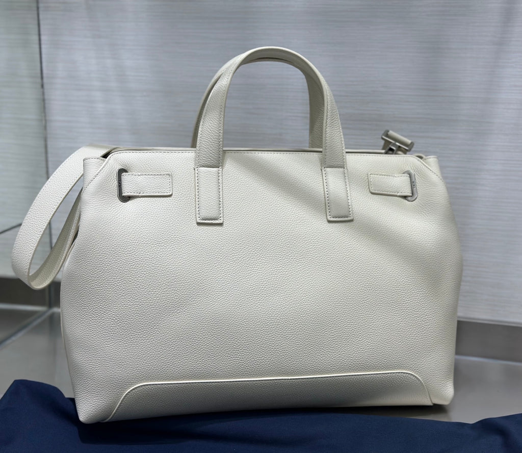 White Dior handbag with top handles and side strap, structured rectangular shape