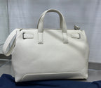 White Dior handbag with top handles and side strap, structured rectangular shape