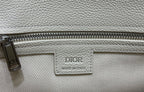 White Dior handbag zipper pocket with “CD” charm and DIOR Made in Italy label