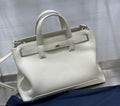 White Dior tote handbag with top handles, front strap, and silver-tone hardware