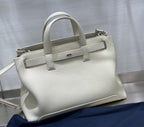White Dior tote handbag with top handles, front strap, and silver-tone hardware