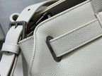 White Dior handbag close-up with front pocket tab and strap hardware