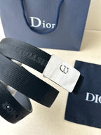Dior belt close-up with dark ribbed strap and silver rectangular buckle