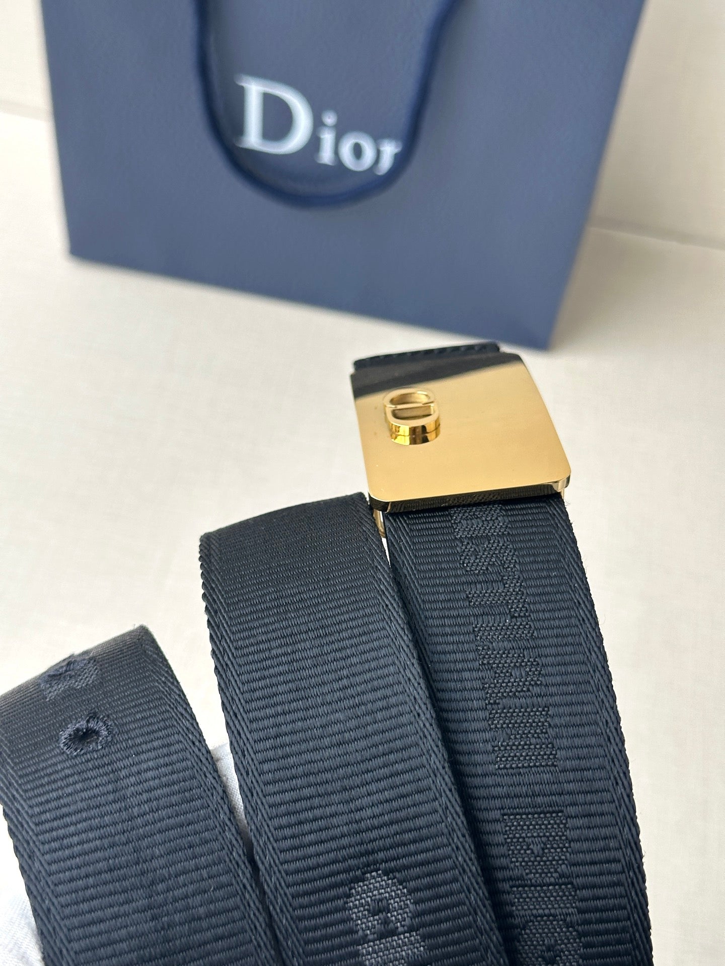 Leather belt with dark textured strap and gold rectangular buckle