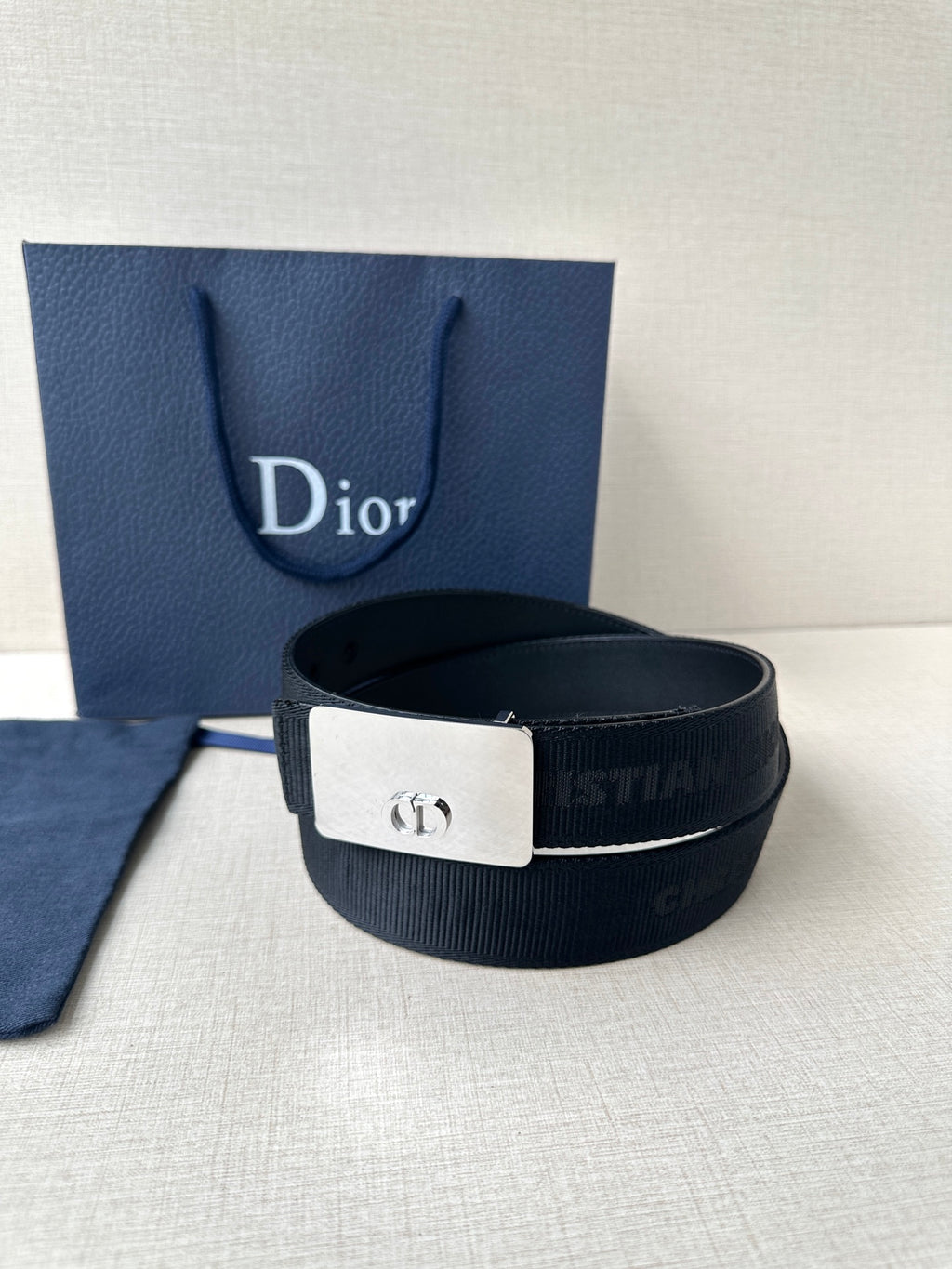 Dior belt with dark strap and silver buckle plate featuring Dior emblem