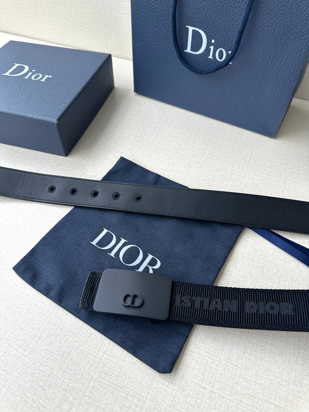 Dior belt with dark blue strap and Dior logo print near the buckle