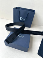 Dior belt laid flat with dark blue strap and matte buckle