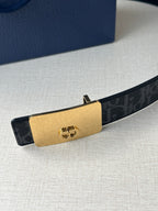 Designer belt with dark monogram strap and gold-tone logo buckle plate