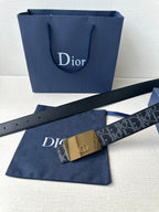 Designer belt with dark strap and gold-tone rectangular buckle with logo