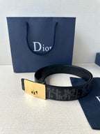 Designer belt with dark monogram strap and gold-tone rectangular buckle