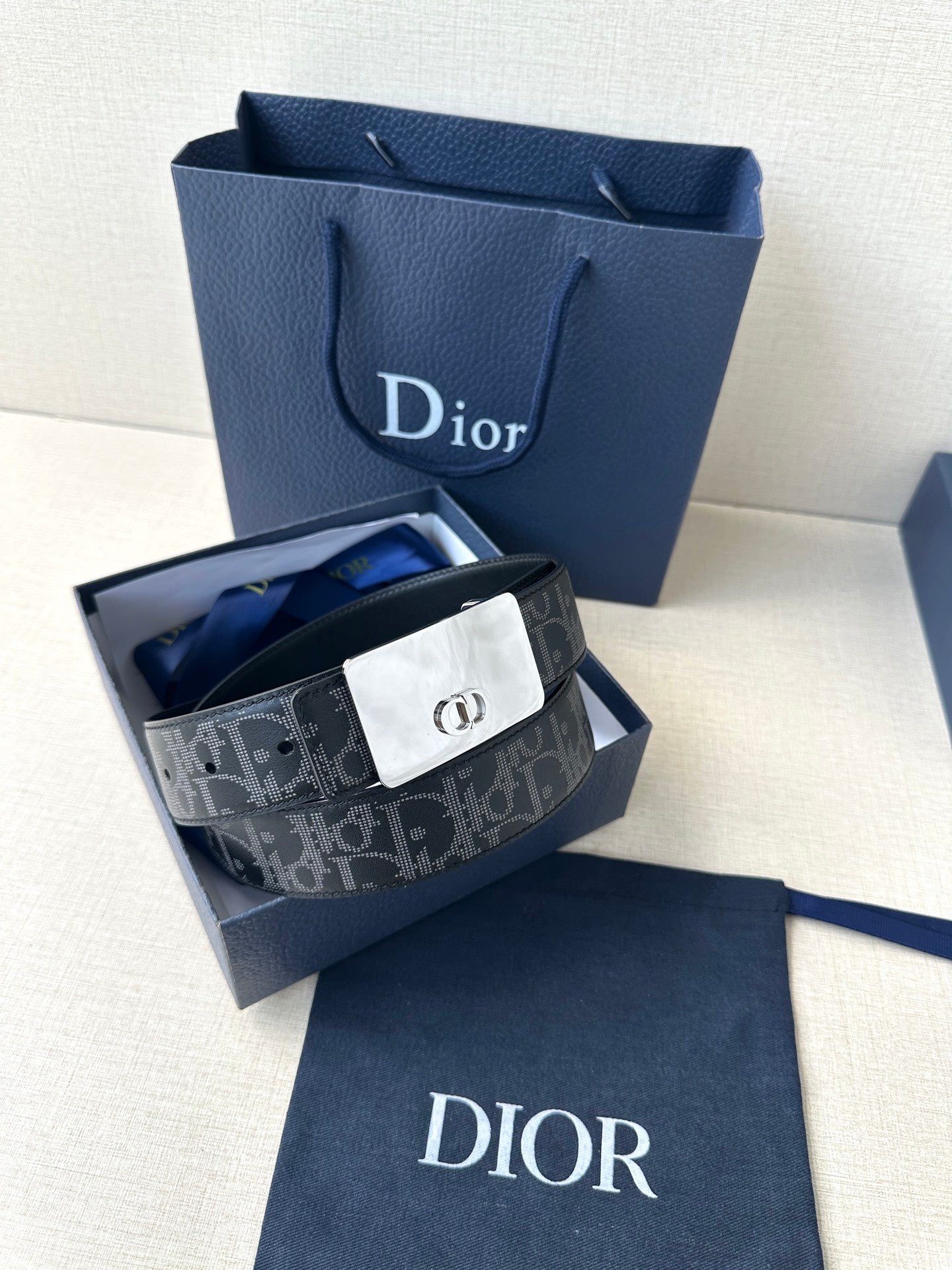 Designer belt with patterned dark strap and silver-tone clasp buckle