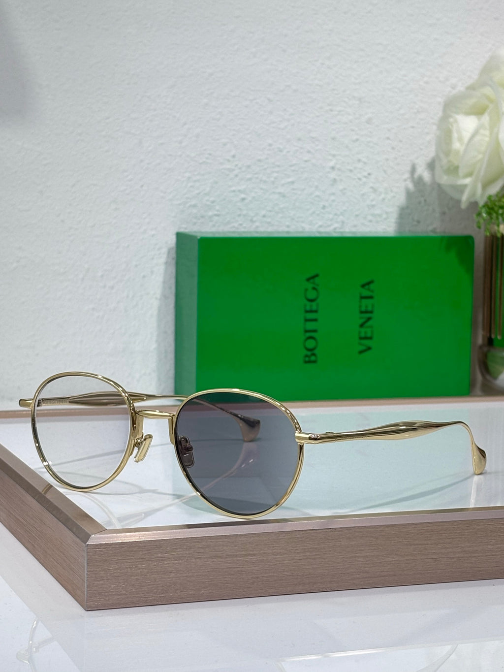 Bottega Veneta round sunglasses with dark lenses and gold-tone metal frame, metal temples