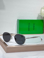 Bottega Veneta round sunglasses with black lenses and silver metal frame, slim temples