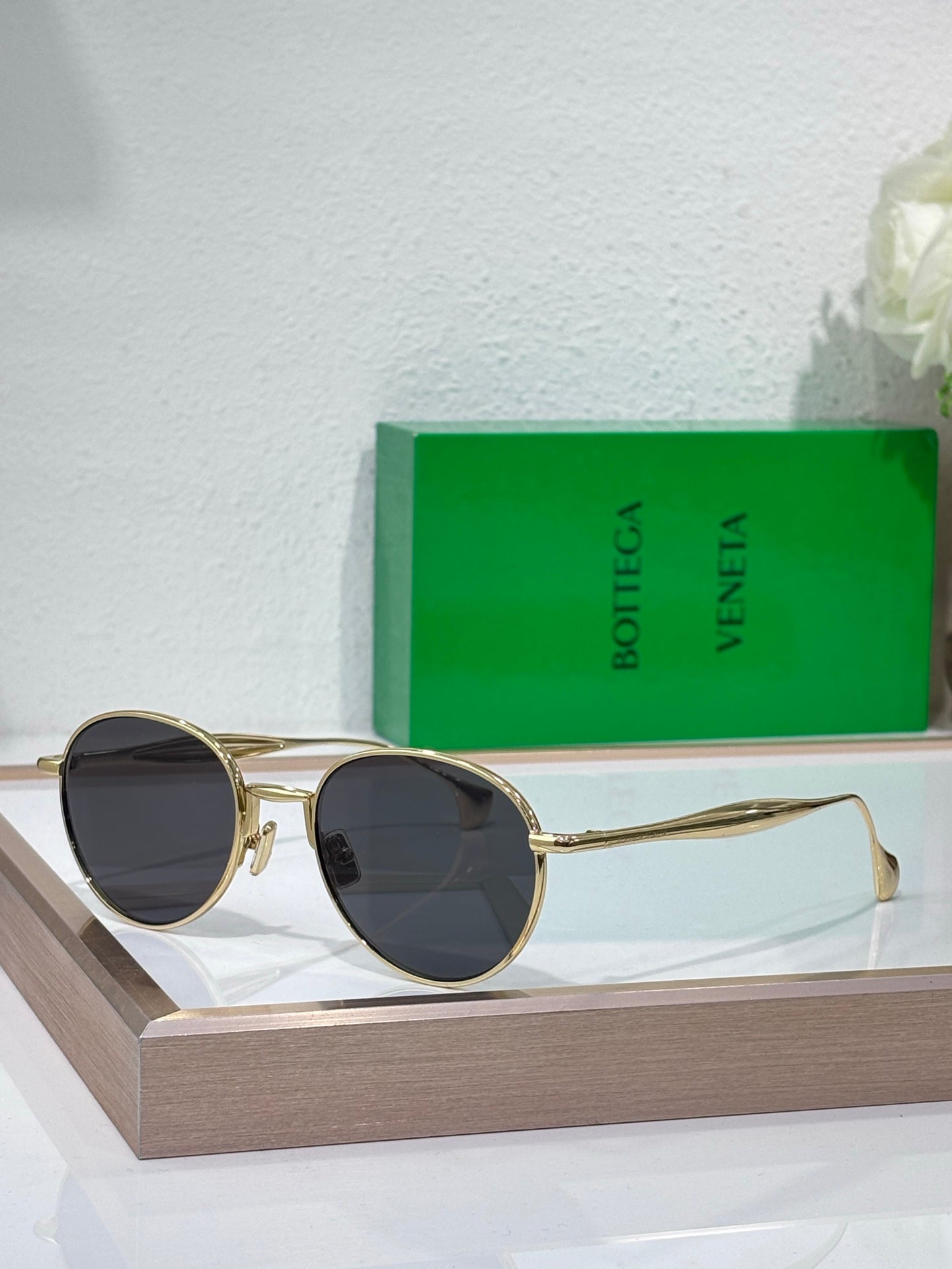 Bottega Veneta round sunglasses with dark lenses and gold-tone metal frame, slim temples