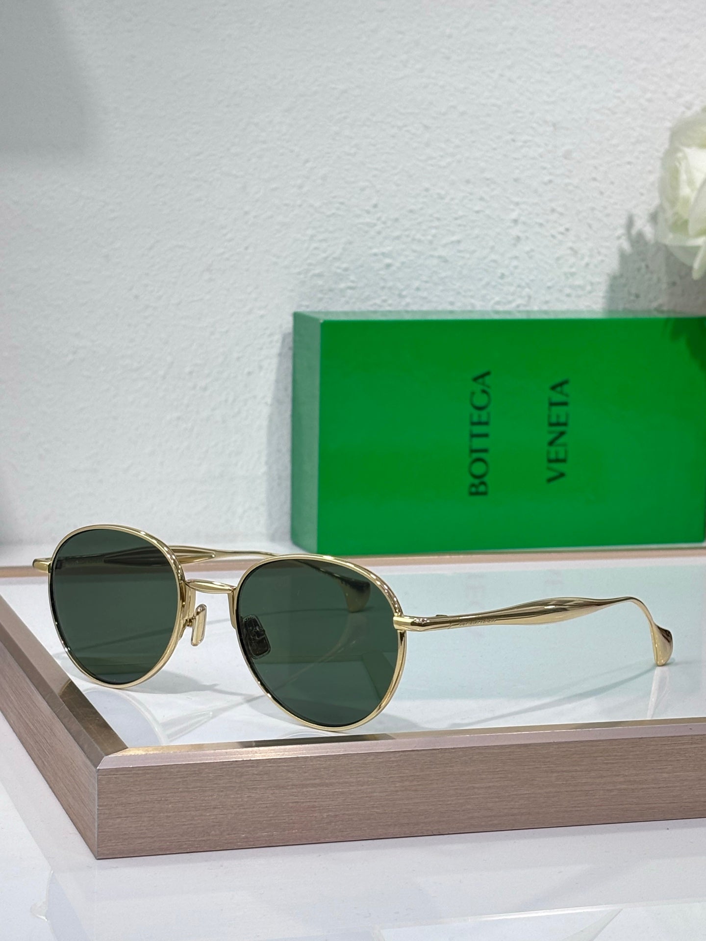 Bottega Veneta round sunglasses with dark green lenses and gold-tone frame, slim temples