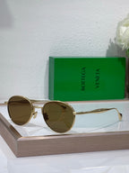 Bottega Veneta round sunglasses with dark lenses and silver metal frame, slim temples