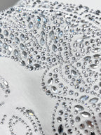 Close-up of Versace rhinestone embellishments on white T-shirt fabric